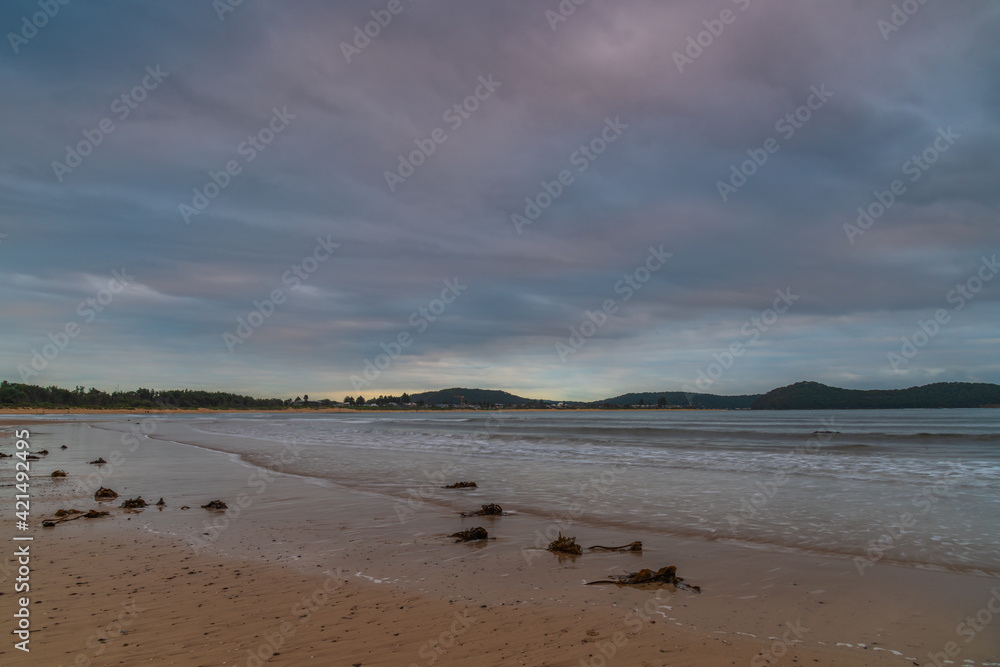 Large cloud cover filing the sky during sunrise at the beach