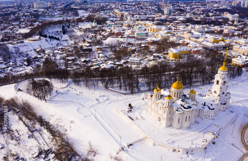 View from drone of picturesque Vladimir city landscape overlooking golden domes of Dormition Cathedral on winter day, Russia