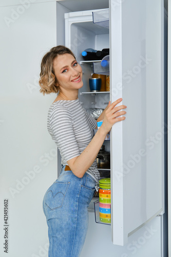 Portrait of a woman taking out the fridge breakfast products