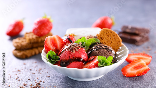 bowl of ice cream with strawberry and biscuit