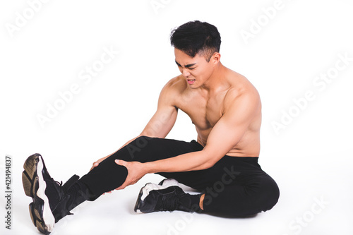muscle fitness man reaching for his leg in pain