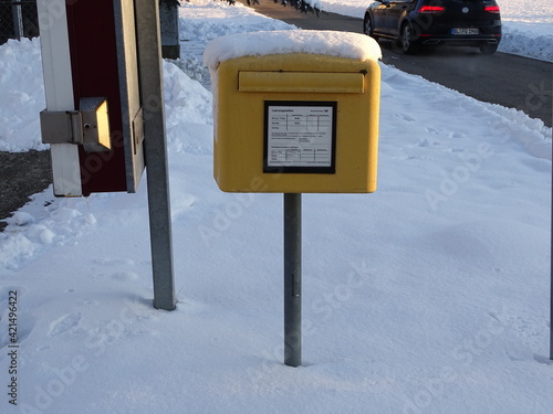 a yellow mailbox with snow