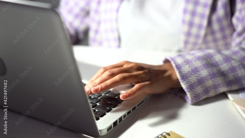 Attractive Indian mixed-race woman typing laptop keyboard at evening office. Business woman working on laptop in studio Attractive Indian mixed-race woman typing laptop keyboard at evening office. Business woman working on laptop in studio