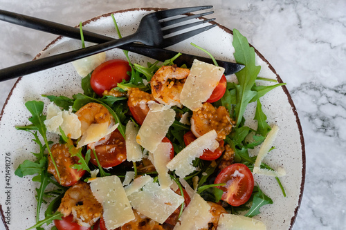 top view of salad with arugula, shrimps and parmesan cheese