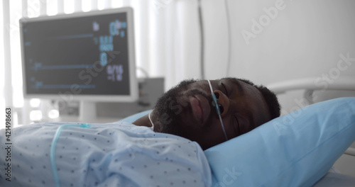 African dead man with oxygen nasal tube lies in hospital bed