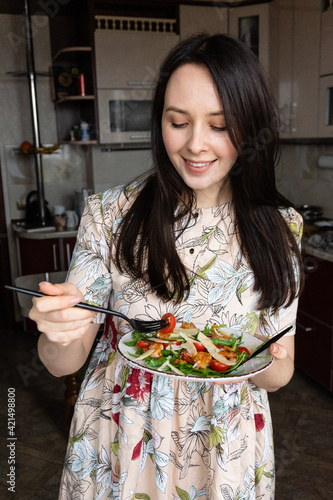 woman eating salad with arugula, shrimps and parmesan cheese