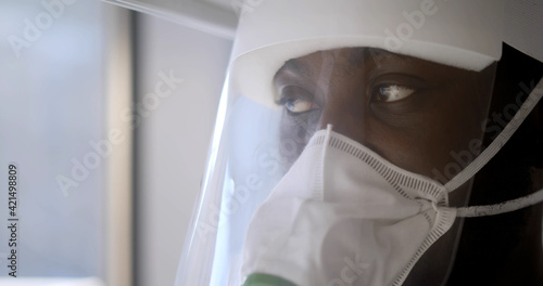 Close up portrait of african doctor wearing respiratory mask and face shield in hospital