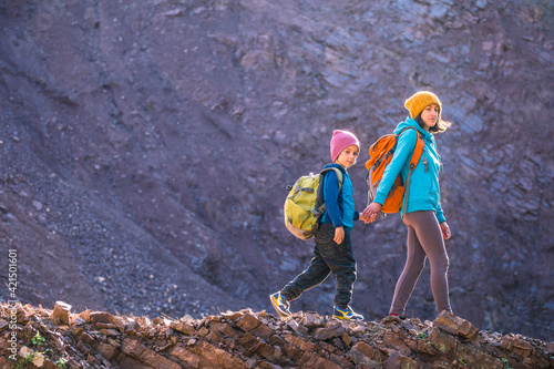 A boy with a backpack travels with his mother.