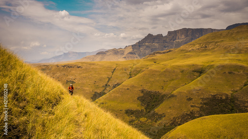 Hiker walking through the valley of Drakensburg, South Africa. October 2019