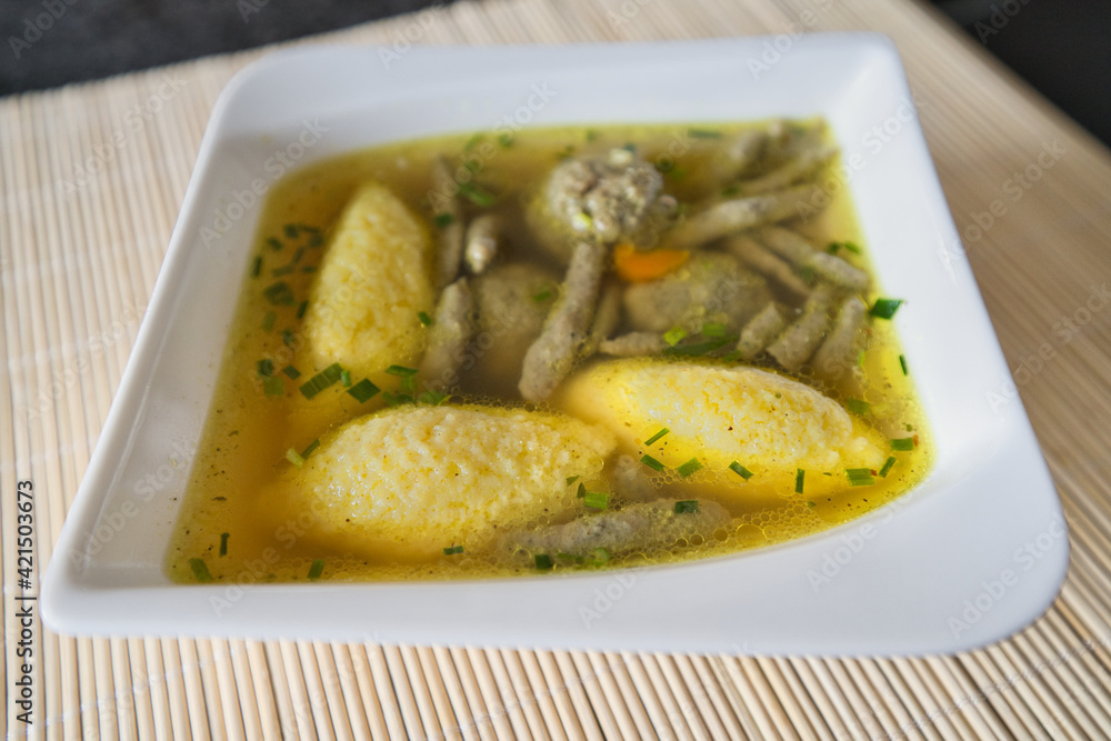 Suppe mit Nockerl, Leberspätzle, kleinen Leberknödel , Kurkuma und Kräutern servieren Suppe mit Nockerl, Leberspätzle, kleinen Leberknödel , Kurkuma und Kräutern servieren