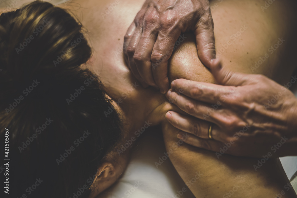 Soft focus view of man massaging a woman in a wellness center. Oiled hands on a body relaxing the muscles and relieve tension. .Olystic xercise for calm and clear your mind. Health well-being concept Soft focus view of man massaging a woman in a wellness center. Oiled hands on a body relaxing the muscles and relieve tension. .Olystic xercise for calm and clear your mind. Health well-being concept