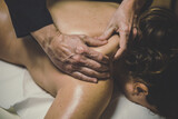 Soft focus view of man massaging a woman in a wellness center. Oiled hands on a body relaxing the muscles and relieve tension.  .Olystic xercise for calm and clear your mind. Health well-being concept