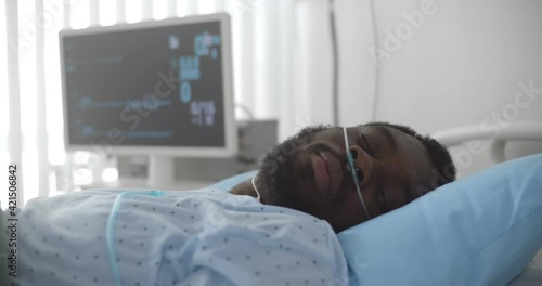 African dead man with oxygen nasal tube lies in hospital bed
