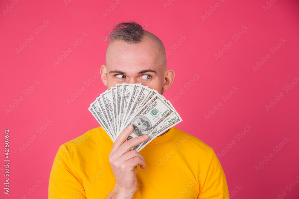 European man on pink red background with fan on 100 dollars positive isolated space European man on pink red background with fan on 100 dollars positive isolated space
