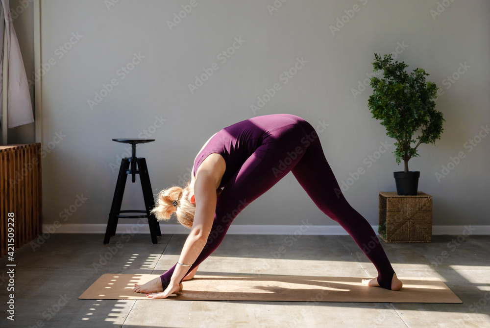 Woman in the gym doing stretching yoga exercises. Healthy sports lifestyle, sportswear for activity. Woman in the gym doing stretching yoga exercises. Healthy sports lifestyle, sportswear for activity.