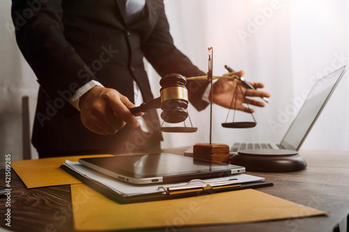 Business and lawyers discussing contract papers with brass scale on desk in office. Law, legal services, advice, justice and law concept picture with film grain effect