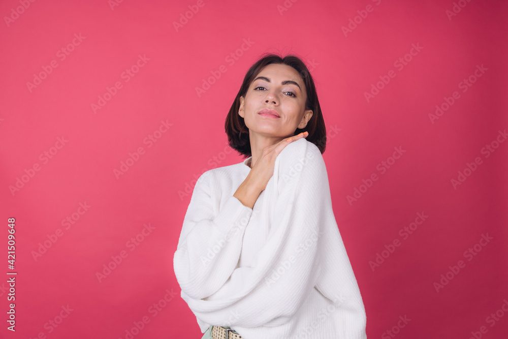 Beautiful woman in casual white sweater on pink red background love concept, holding hands crossed hugging herself isolated copy space Beautiful woman in casual white sweater on pink red background love concept, holding hands crossed hugging herself isolated copy space