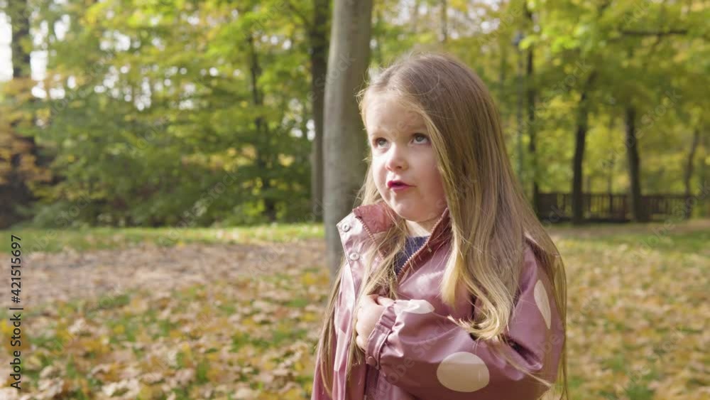 Cute little Caucasian girl disagrees and shakes her head in a park - closeup Cute little Caucasian girl disagrees and shakes her head in a park - closeup