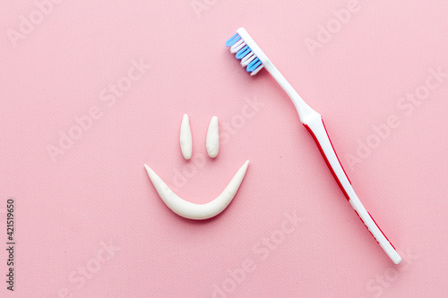 Smile shape of toothpaste with toothbrush, top view. Oral care and hygiene