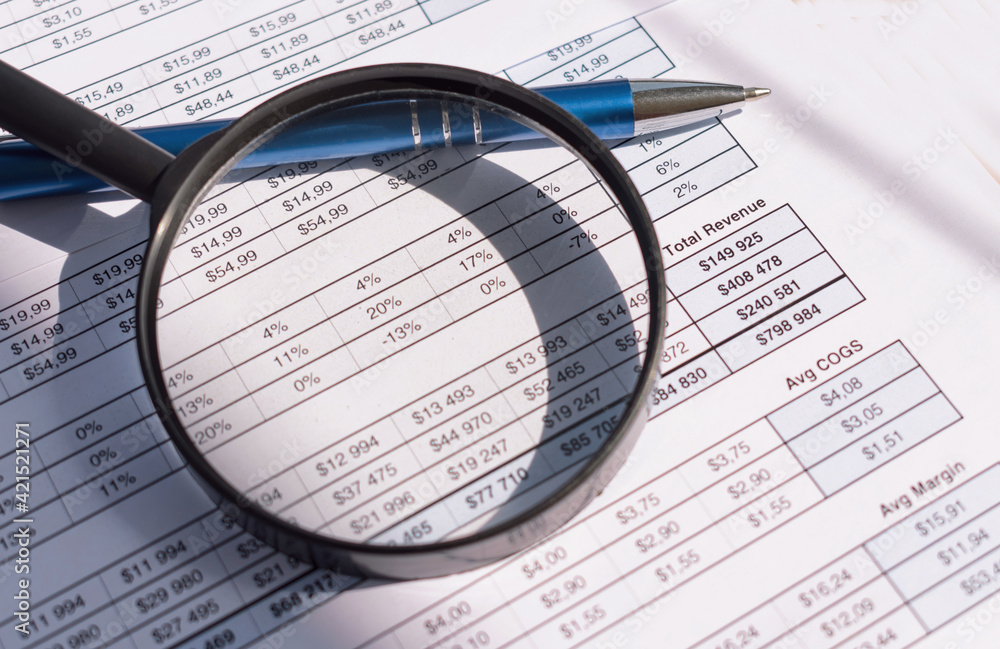 Financial documents with pen and magnifying glass. Financial documents with pen and magnifying glass.
