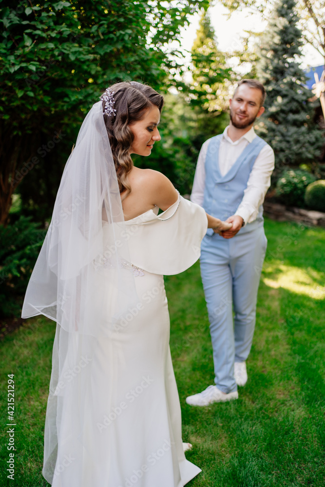 newlyweds on a walk in a summer park. wedding photo shoot.