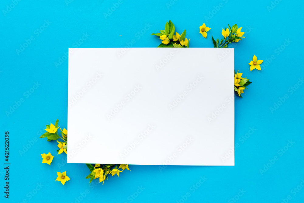 White paper mock up with yellow flowers, view from above White paper mock up with yellow flowers, view from above