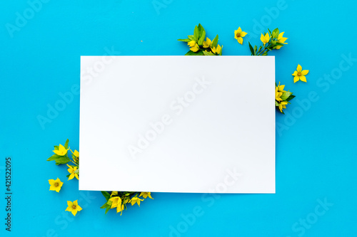 Fototapeta Naklejka Na Ścianę i Meble -  White paper mock up with yellow flowers, view from above