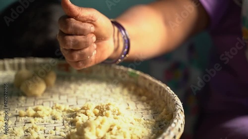 Woman making thekua by hand for chhath puja photo