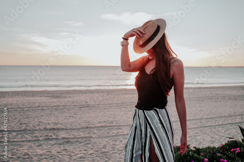 young woman with hat on beach on vacation