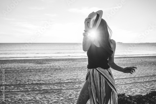 young woman with hat on beach on vacation