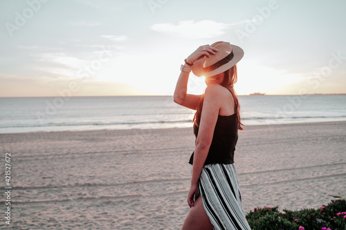 young woman with hat on beach on vacation