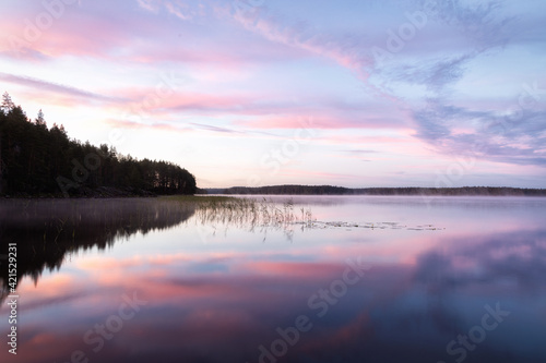 sunset on the lake with a pink sky and the beautiful reflection in the lake