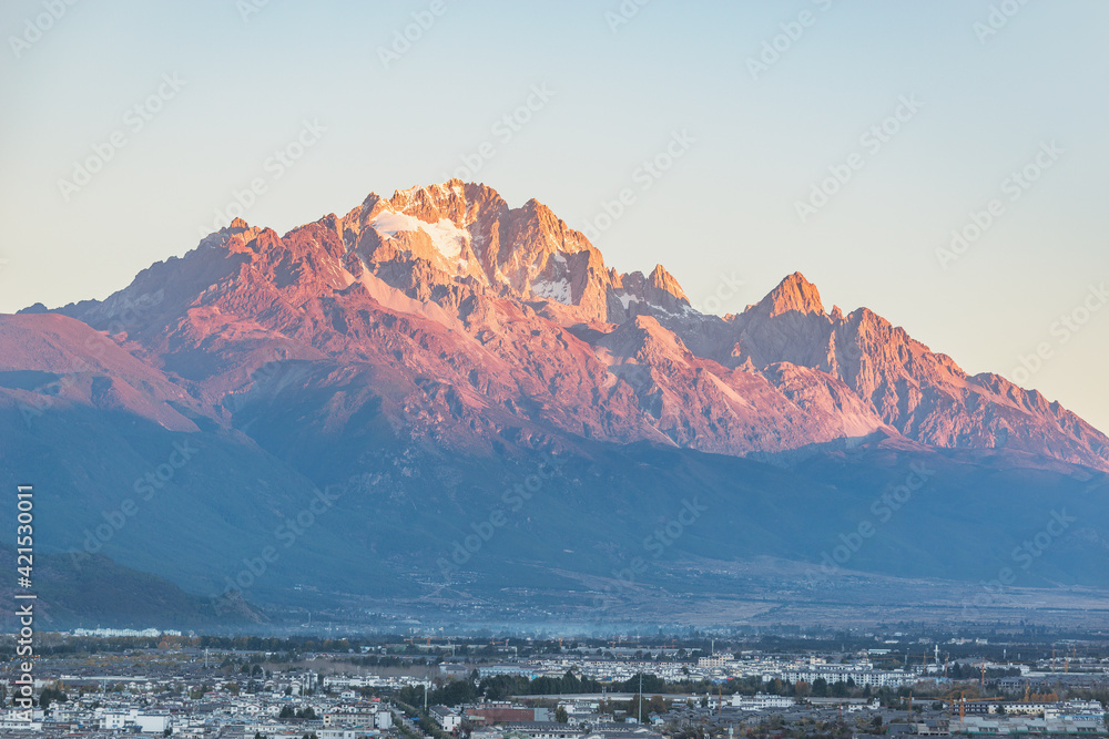 Jade Dragon Snow Mountain by the city at sunrise. Lijiang.
