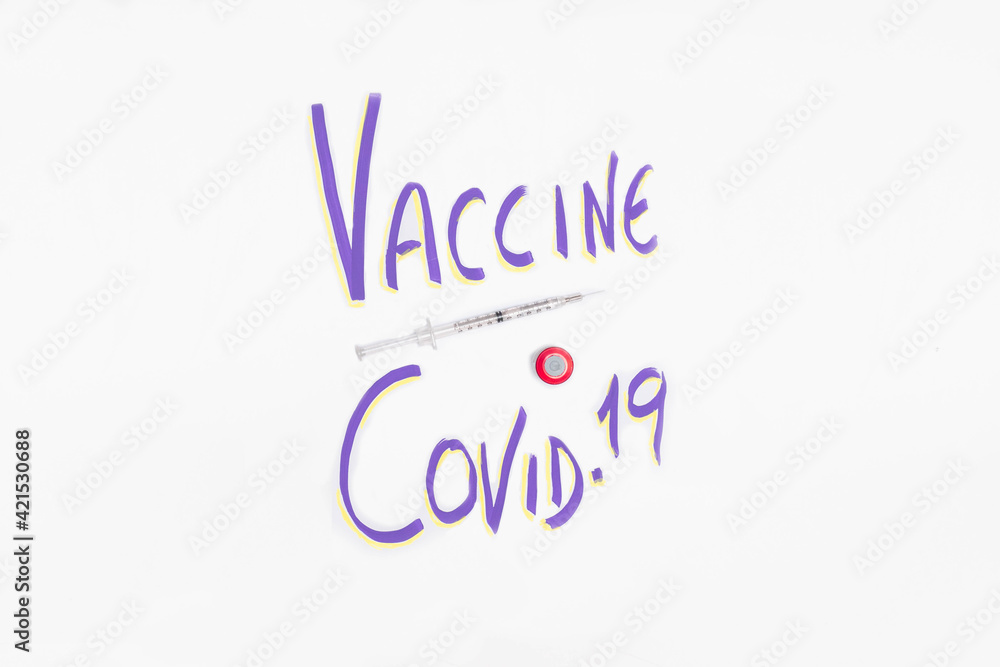 Selective focus of a poster with Covid19 Vaccine letters and a syringe with the vaccine for the end of disease concept health