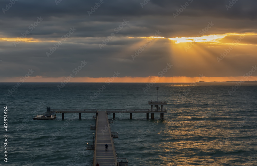Dramatic sunrise on the beach in Burgas, Bulgaria. Sunrise on the Burgas Bridge. Bridge in Burgas - symbol of the city. 