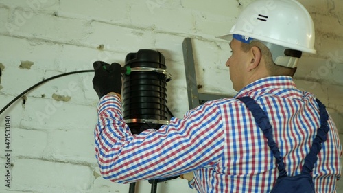 A network engineer works with optical fiber equipment