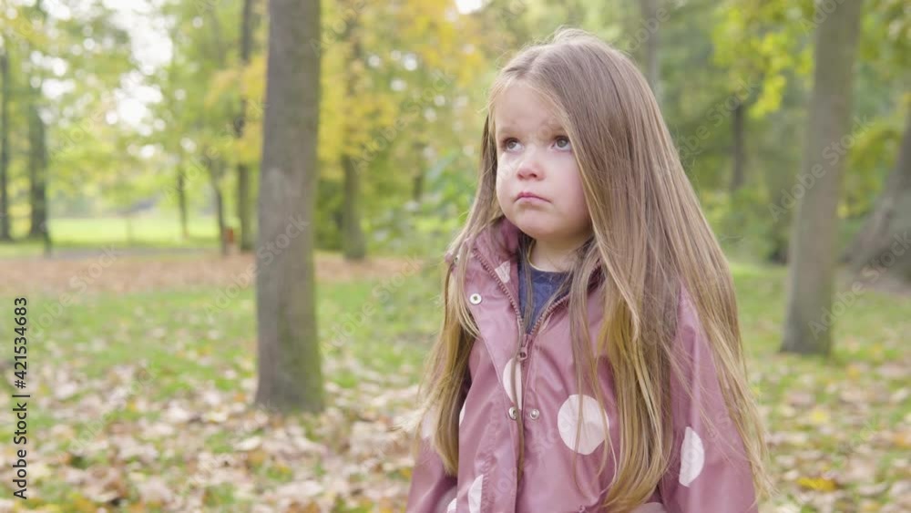 Cute little Caucasian girl disagrees, shakes her head and gesticulates in a park - closeup Cute little Caucasian girl disagrees, shakes her head and gesticulates in a park - closeup