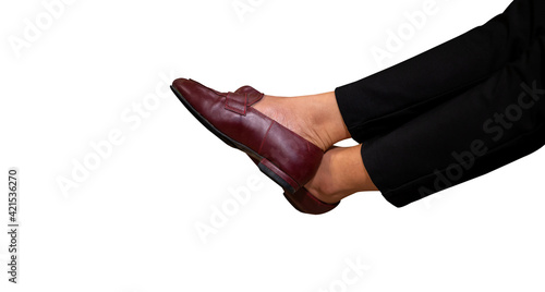 Womens feet wearing brown leather shoes with Black trousers isolated on white background