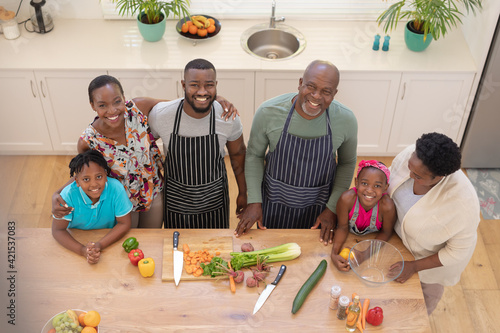 Fototapeta Portrait of happy african american parents with son and daughter and grandparents in the kitchen