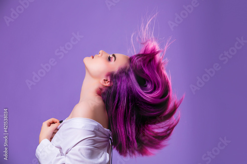 Model girl young beautiful stylish with hair dyed purple on violet background photo