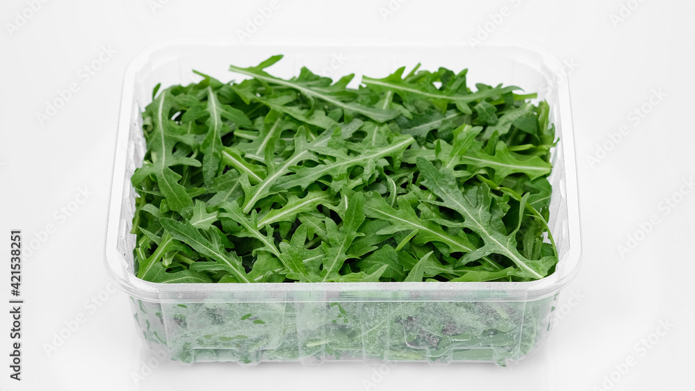 fresh arugula in container for delivery or sale on white background fresh arugula in container for delivery or sale on white background