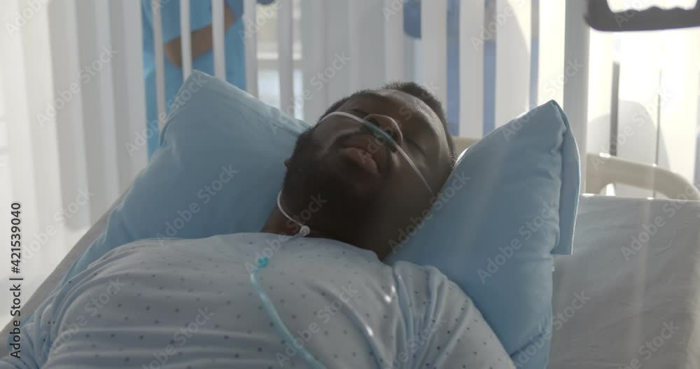 African-american male patient with nasal cannula having fever lying in hospital bed African-american male patient with nasal cannula having fever lying in hospital bed