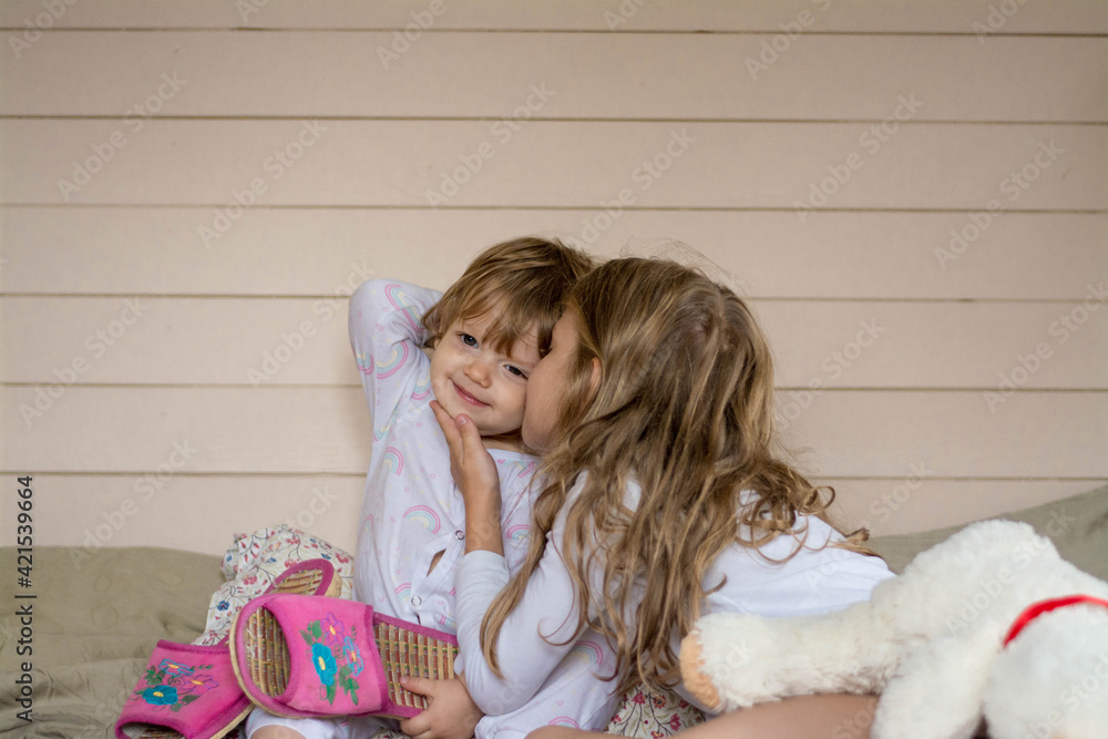 Two sisters hug each other and smile. Two sisters hug each other and smile.