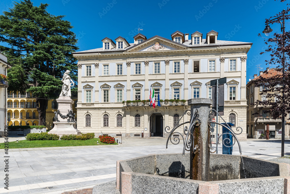 Beautiful square in an old city in Europe. Domodossola, ancient city in northern Italy, historic center with the Palazzo di Città, as written above the entrance, (year 1847), seat of the town hall 