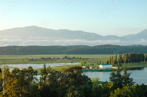 Fototapeta Naklejka Na Ścianę i Meble -  Beautiful landscape at sunset. Panoramic view of the lake and snow-capped mountain peaks. Mountains covered in haze and the ancient lake Inkit. Pitsunda. Abkhazia.