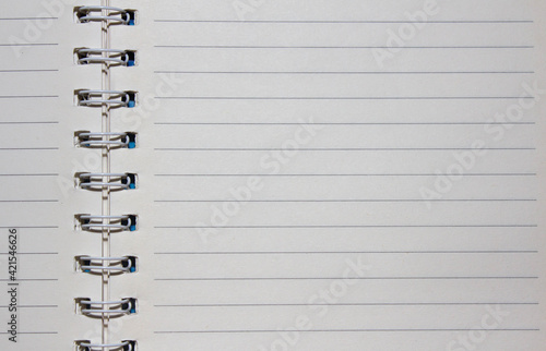 Notebook on a spiral spring with textured papper of white color as the background