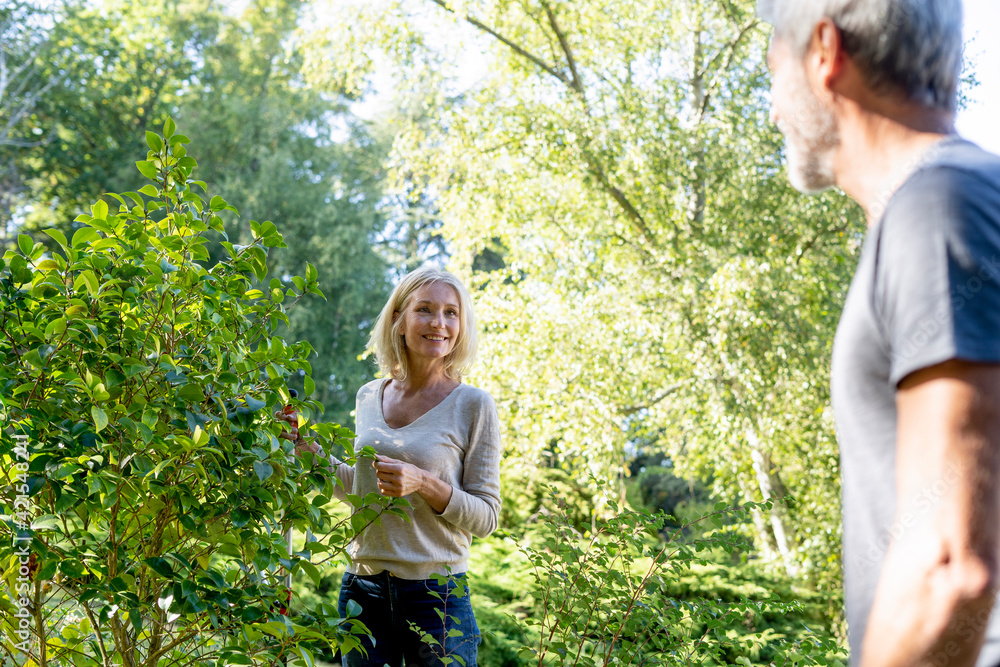 Mature couple looking at each other while gardening in backyard Mature couple looking at each other while gardening in backyard