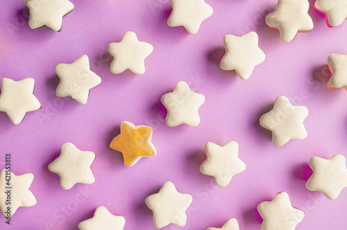 Background of jelly candies in the shape of a star. Stars of fruit marmalade on a pink solid background. Top view