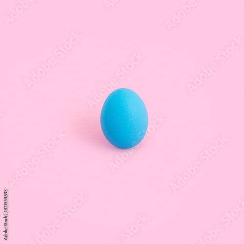 Creative minimal Easter concept with blue color egg on pastel pink background