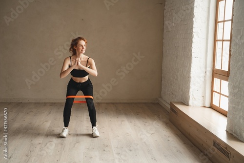 Woman training with resistance bands at health club. Sporty attractive female working out © Ivan